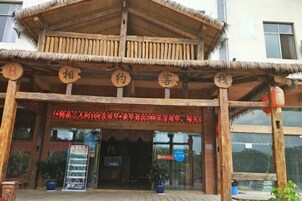 Un edificio de madera tradicional con techo de paja y caracteres chinos en la fachada.