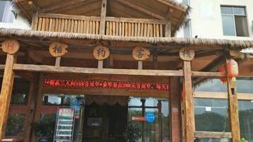A traditional wooden building with a thatched roof entrance.