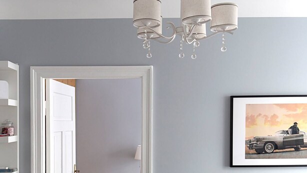 A modern living room with a grey sofa, a chandelier, and a framed picture on the wall. - Vintage Apartments Blue / Free parking (Rīga)
