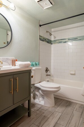 A bathroom with a toilet, sink, and bathtub. - Coastal Condo with Side Ocean View Balcony (Belleair Beach)