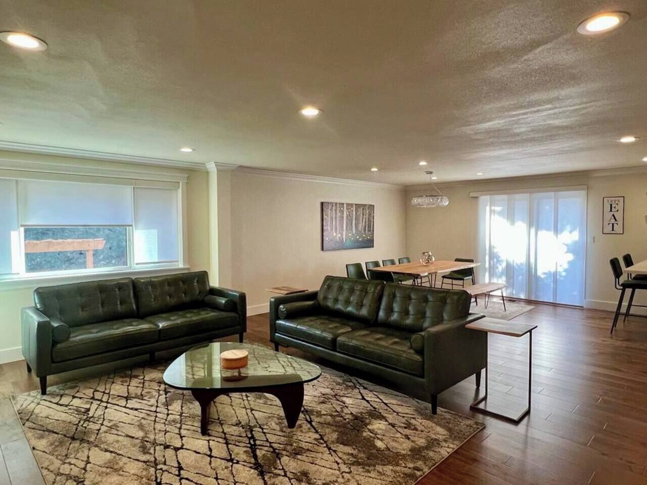Un salon comprenant deux canapés, une table basse et un coin repas avec une table et des chaises.
