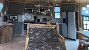 Una cocina amplia con vigas de madera en el techo, una isla central y electrodomésticos modernos.