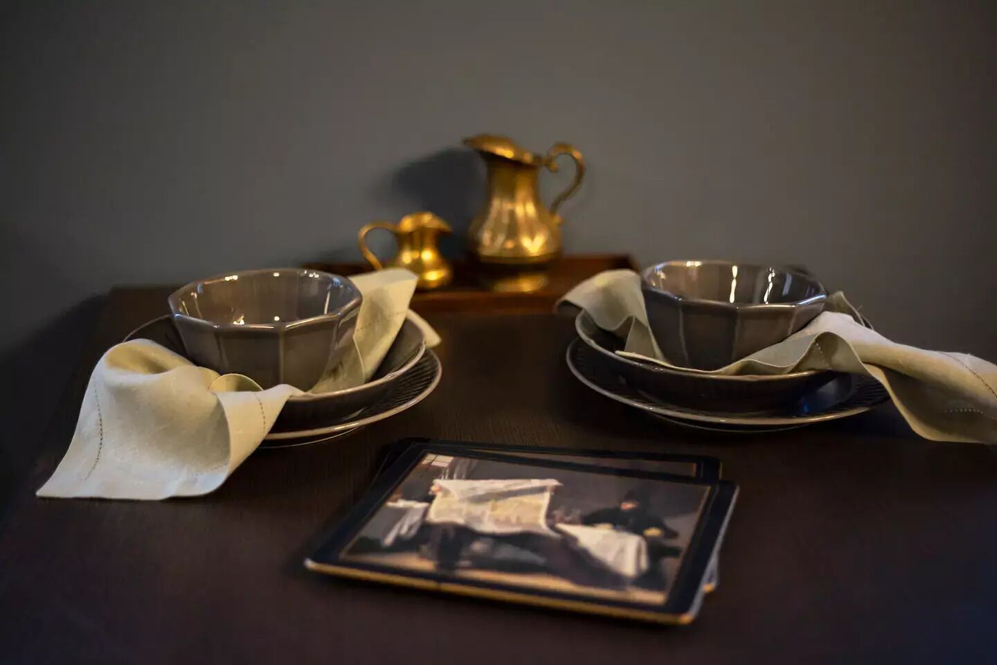 Une table avec deux bols, une carafe et une tablette.