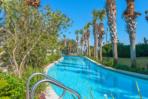 A swimming pool surrounded by tall palm trees and lush greenery.