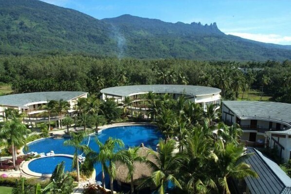 Surrounded by lush greenery and palm trees, this resort offers a tranquil atmosphere and a central swimming pool.