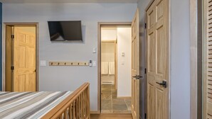 Una camera da letto con un letto, un armadio in legno e una TV a parete.