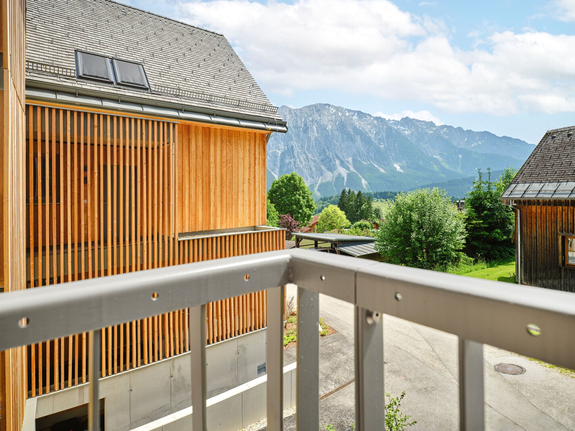 Een houten gebouw met een balkon met uitzicht op een bergachtig landschap.