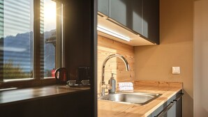 Eine moderne Küche mit einer Holzarbeitsplatte, einer Spüle aus Edelstahl und einem eingebauten Backofen.