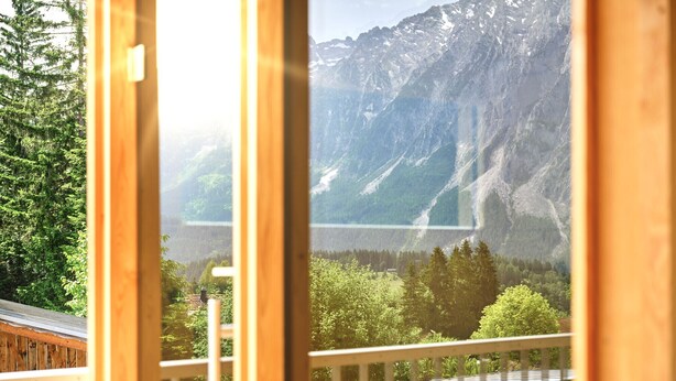 Ein Holzbalkon mit Blick auf einen Berg und einen See.
