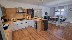 A modern kitchen with a wooden island, white cabinets, and pendant lighting. - New modern villa with private pool 7 km from the sea. (Rovinjsko Selo)