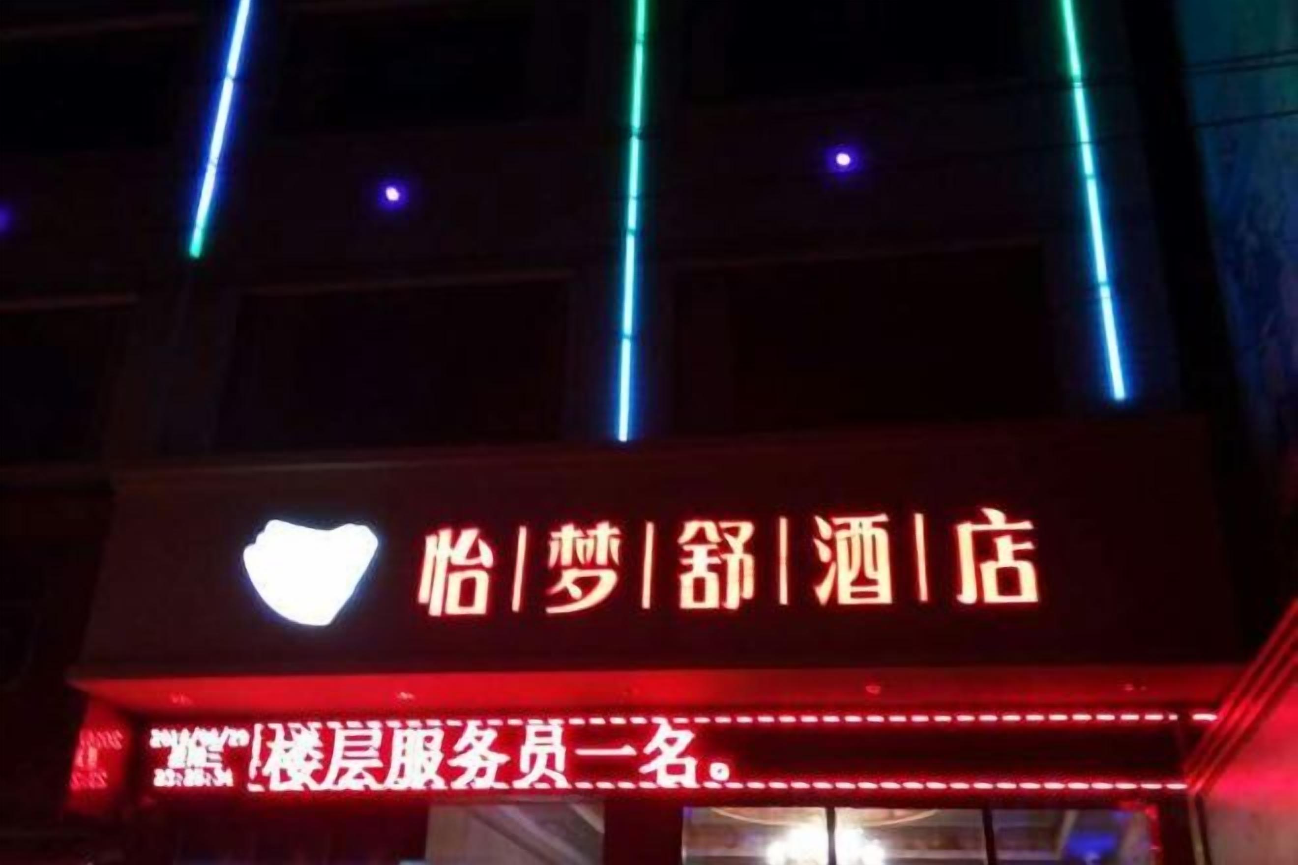 A hotel sign with illuminated text and a heart symbol.