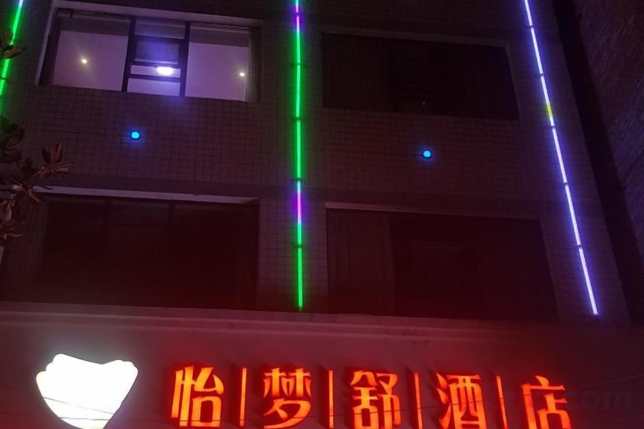 Un edifici amb un rètol que diu 'Hotel' i una làmpada de disseny amb forma de cor.