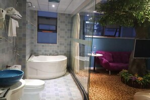 A bathroom with a bathtub, toilet, and a large blue basin. - Yimengshu Hotel (Lichuan)