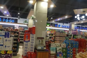 Interior de un supermercado con pasillos llenos de diversos productos, incluyendo artículos en caja y productos para el hogar.