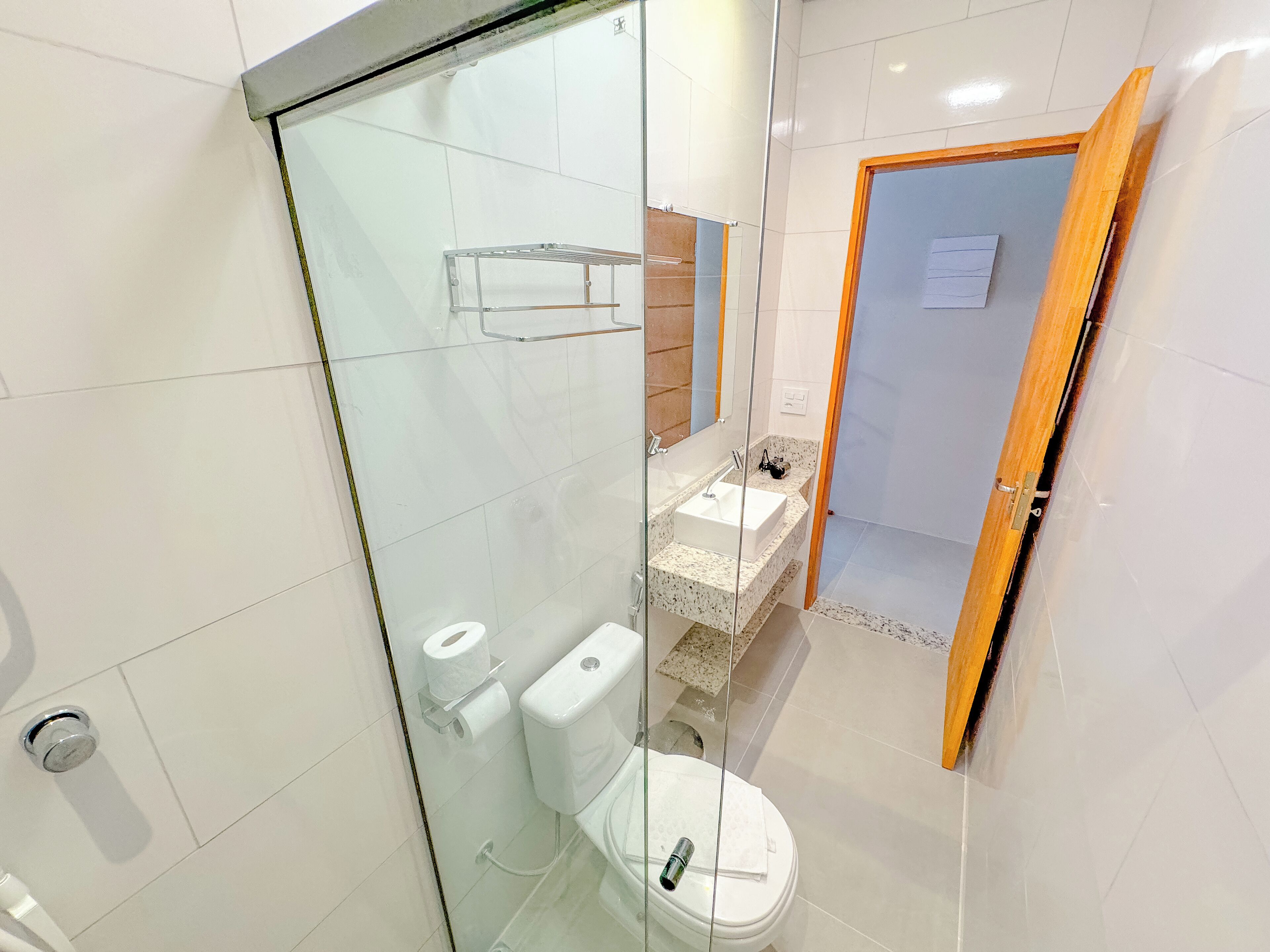 A modern bathroom with a glass shower enclosure, a toilet, and a sink with a vanity.