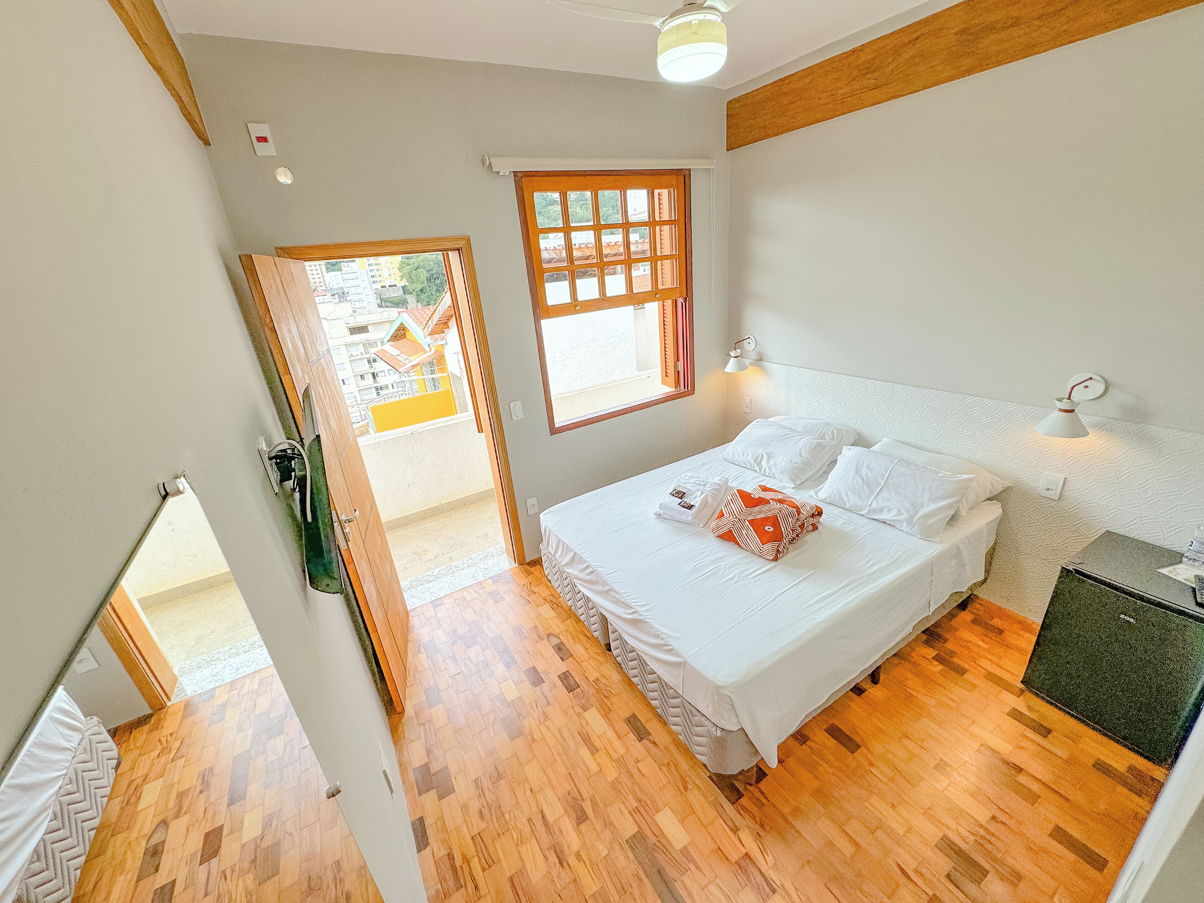 Une chambre à coucher avec un lit, une fenêtre, une porte et un petit bureau.