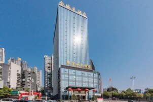 Un edificio moderno de gran altura con una entrada destacada y fachada de vidrio.