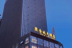 A tall building with a sign that reads 'Gold-N City Hotel.'