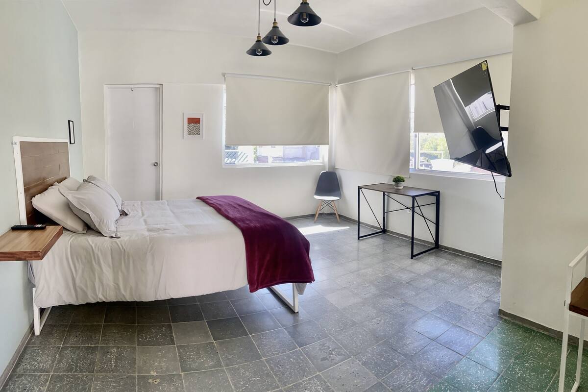 Estudio básico | Espacio para trabajar con un portátil y ropa de cama