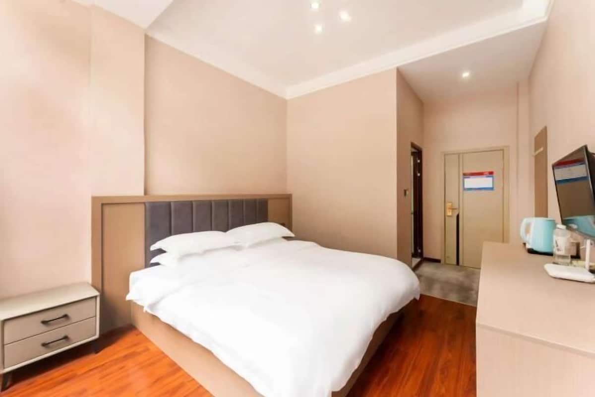 Une chambre d’hôtel équipée d’un lit, d’une table de chevet et d’un bureau avec un ordinateur.