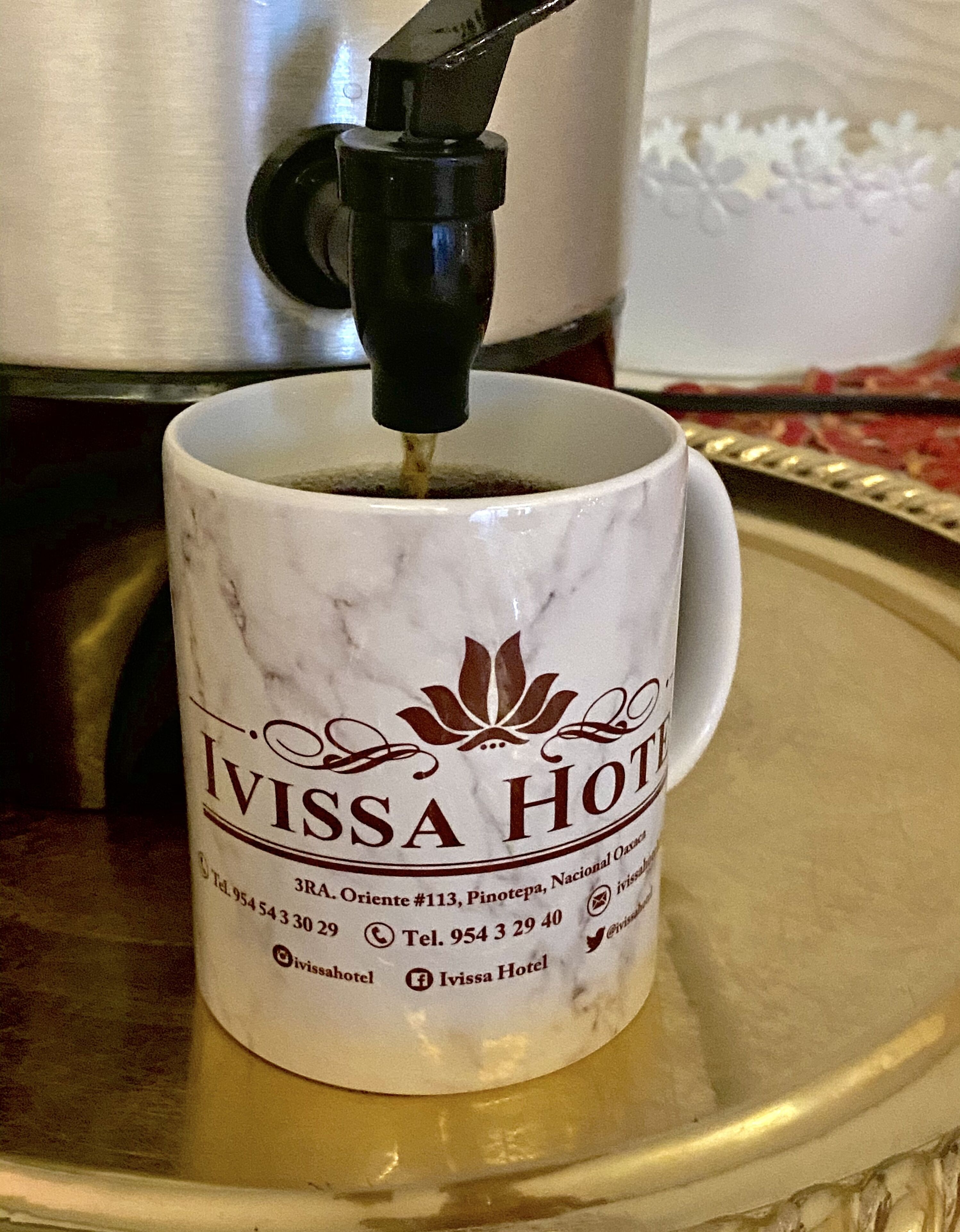 A coffee mug with the text "Ivissa Hotel" and contact information.