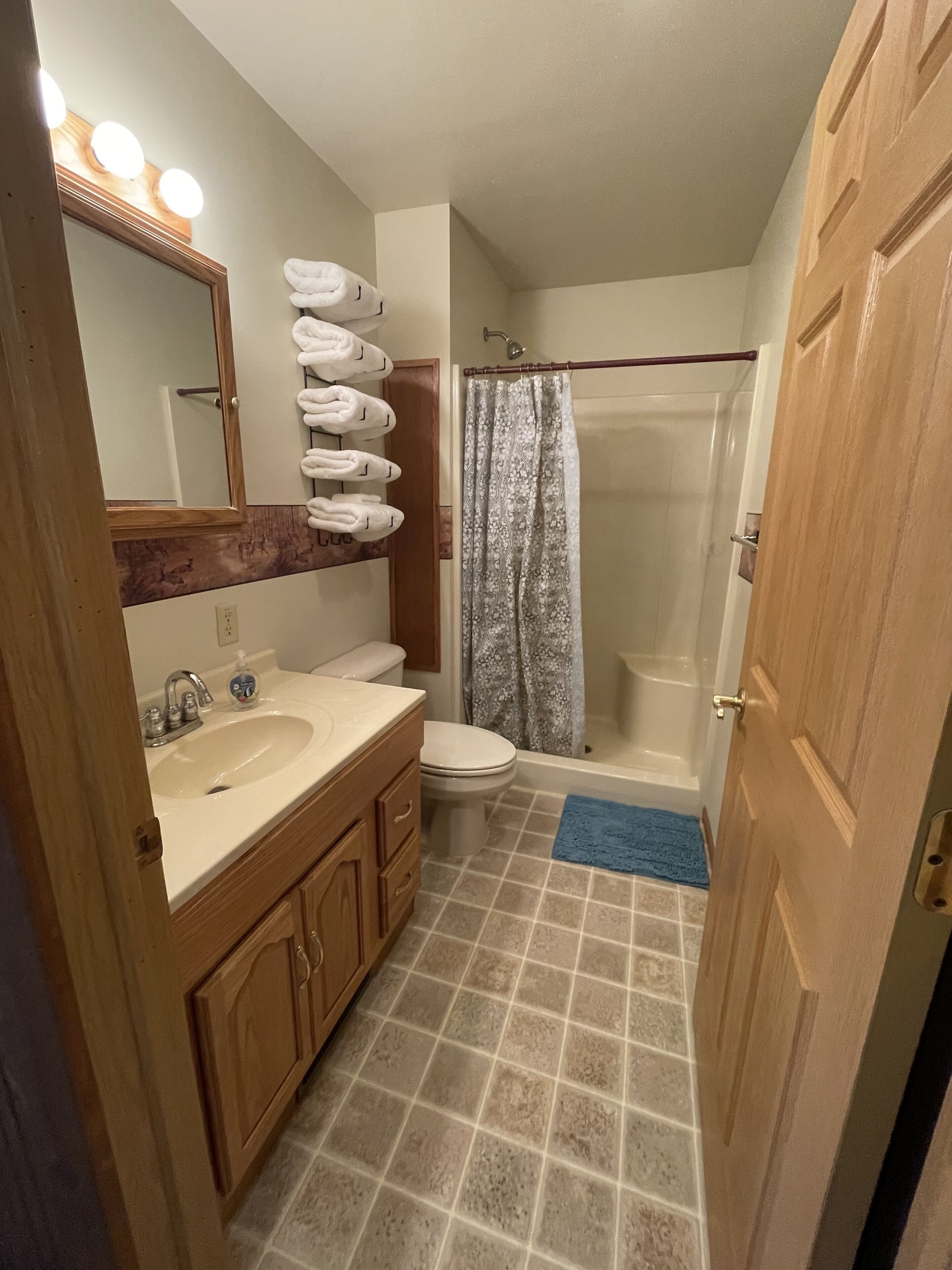 Une salle de bain avec un lavabo, un miroir et un espace douche.