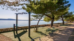 Un parc équipé d’installations d’exercice, doté d’un chemin pavé et offrant une vue sur l’eau.