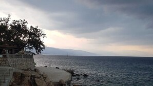 Une vue sur la côte, avec un bâtiment en pierre et un arbre.