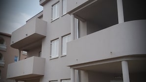 Un edificio de varios pisos con balcones y un espacio de estar al aire libre techado.