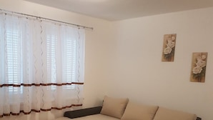 Una sala de estar moderna con un sofá seccional, una mesa de centro de madera y una alfombra negra.
