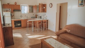 Une cuisine compacte comprenant un coin repas, un canapé et une table basse.