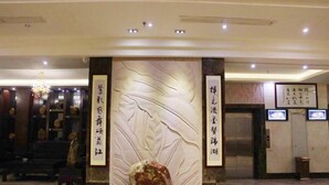 A lobby with a reception desk, a chandelier, and a stone sculpture. - Kumho Hotel (Wengyuan)