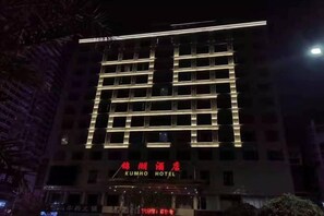 A multi-story hotel with illuminated signage and a prominent entrance. - Kumho Hotel (Wengyuan)