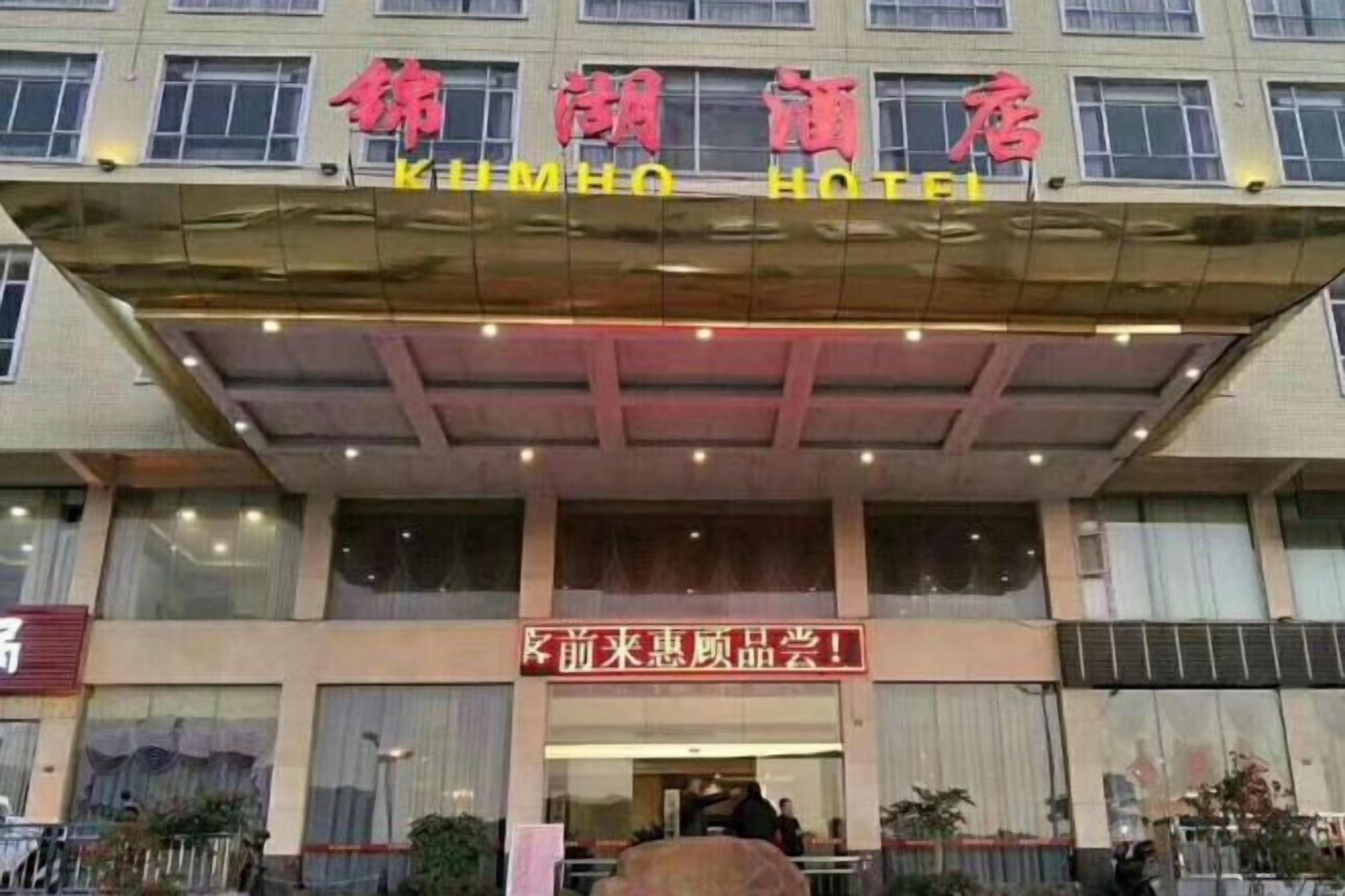 A hotel entrance with a signboard and a covered entrance area.