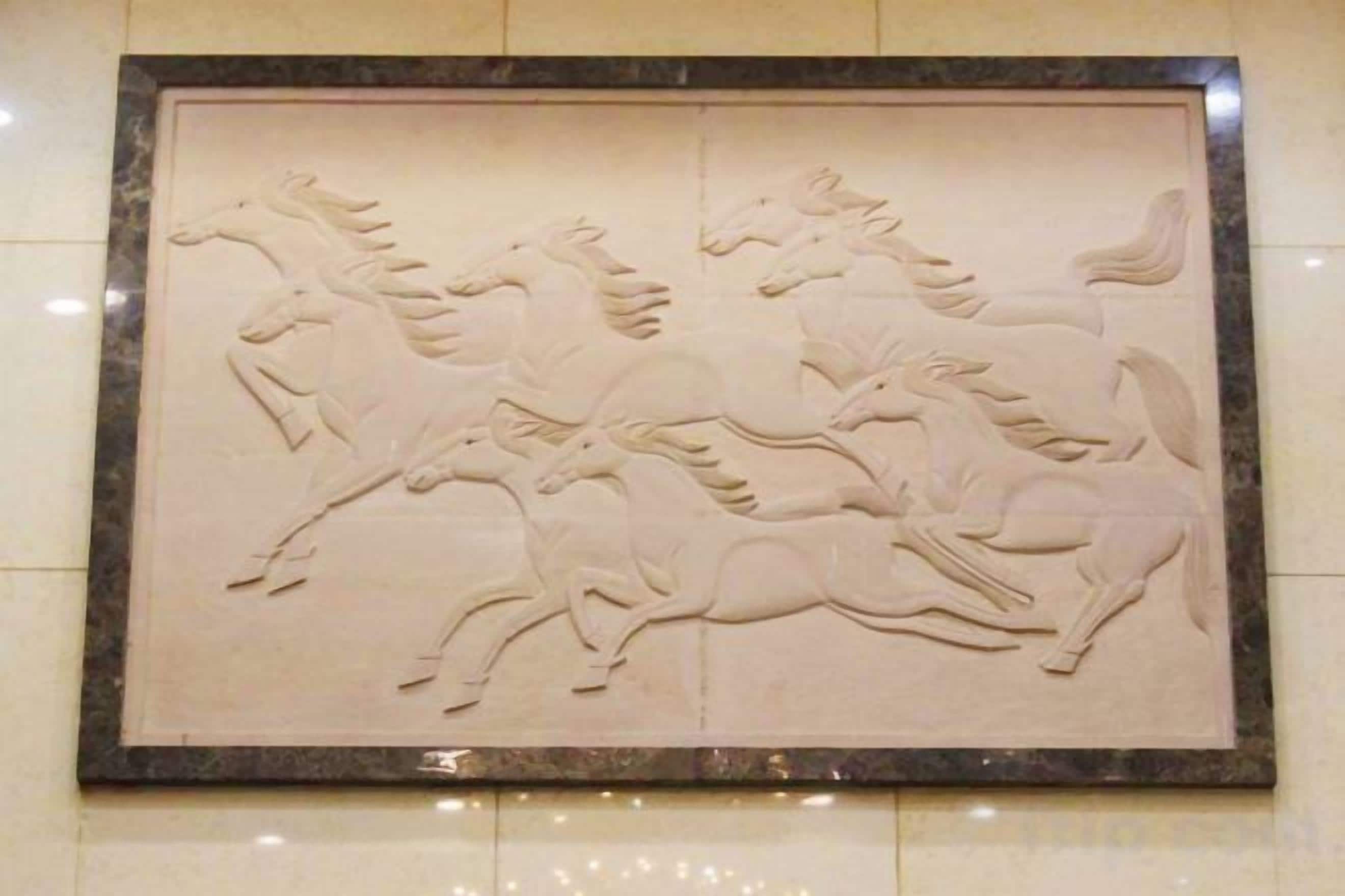 Un bas-relief représentant des chevaux, fixé au mur.
