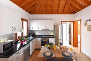 A modern kitchen with white cabinets, stainless steel appliances, and a wooden ceiling. - Casas García, Tijarafe (Tijarafe)