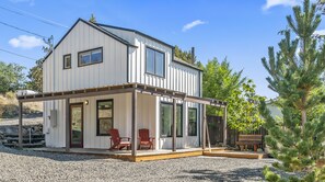 A two-story house with a covered porch, two red Adirondack chairs, and a wooden bench. - Smith Rock Hideout - Cascade mountain views! (Terrebonne)