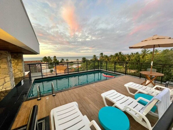 Una piscina al aire libre, una piscina climatizada, sombrillas