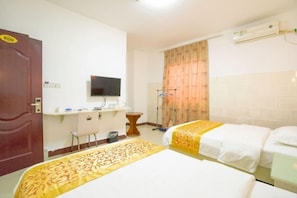 A hotel room with two beds, a desk, a chair, a television, and an air conditioning unit. - Haikou Jinmeng Hotel (Haikou)