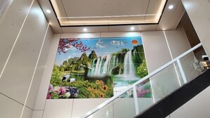 A modern interior with a mural of a waterfall and nature scene. - Haikou Jinmeng Hotel (Haikou)