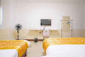 A hotel room with two beds, a desk with a flat-screen TV, a mirror, and a towel rack. - Haikou Jinmeng Hotel (Haikou)