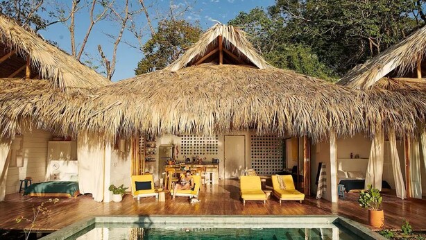 A bungalow with a thatched roof, a pool, and wooden flooring. - Pacific SurfShack Ocean View Mal Pais/Santa Teresa (Santa teresa)