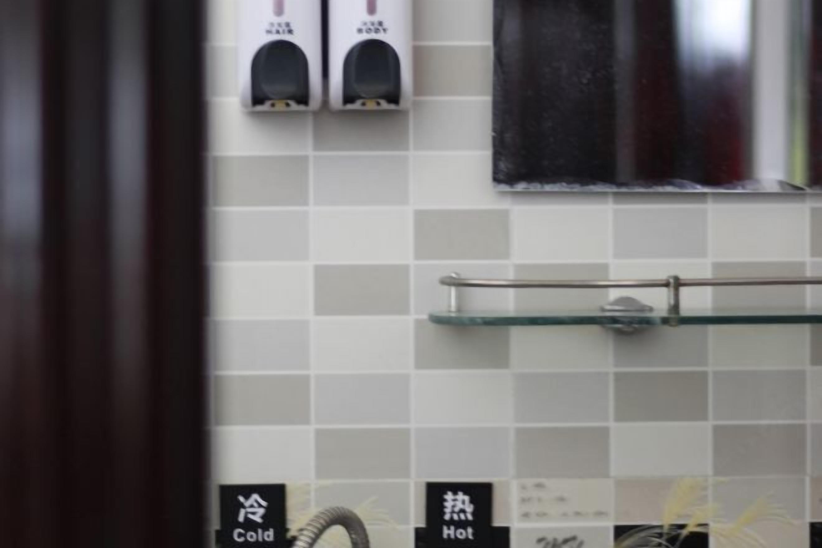 Un baño con pared de azulejos, un perchero y una estantería.