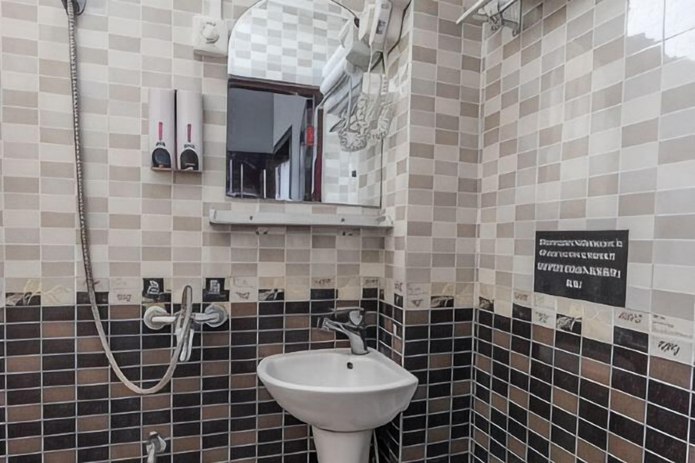 A bathroom with a sink, mirror, and shower.