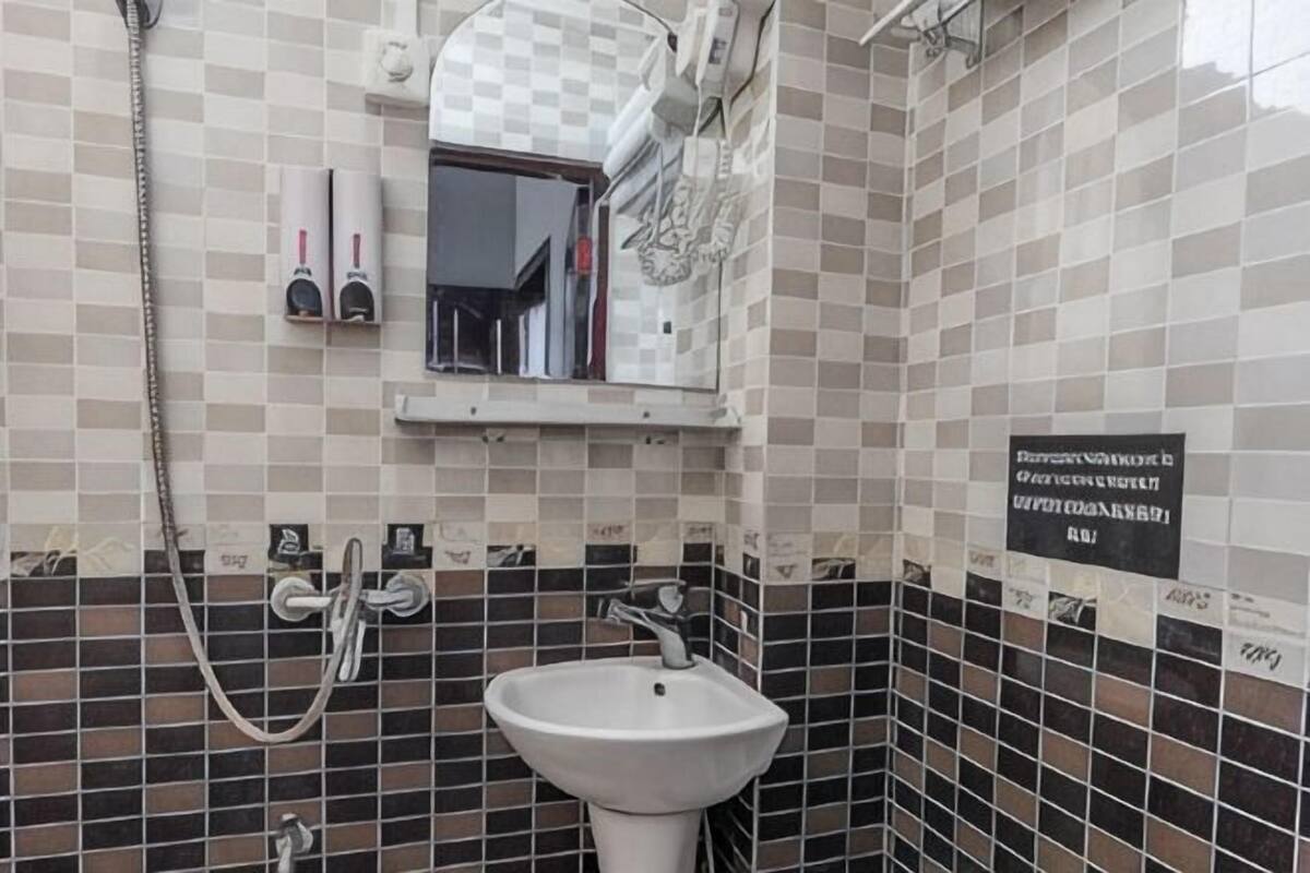 A bathroom with a sink, mirror, and shower.