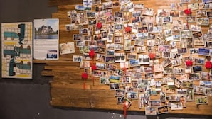 Eine Wand, die mit zahlreichen Fotos und einigen roten Verzierungen bedeckt ist.