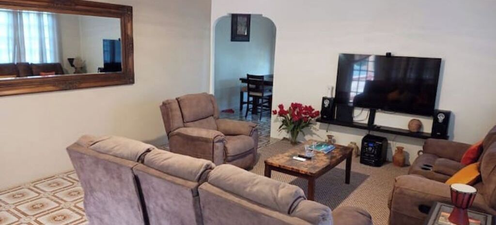 Ein Wohnzimmer mit zwei Sofas, einem Couchtisch, einem Fernseher und einem kleinen Tisch mit Dekoration.