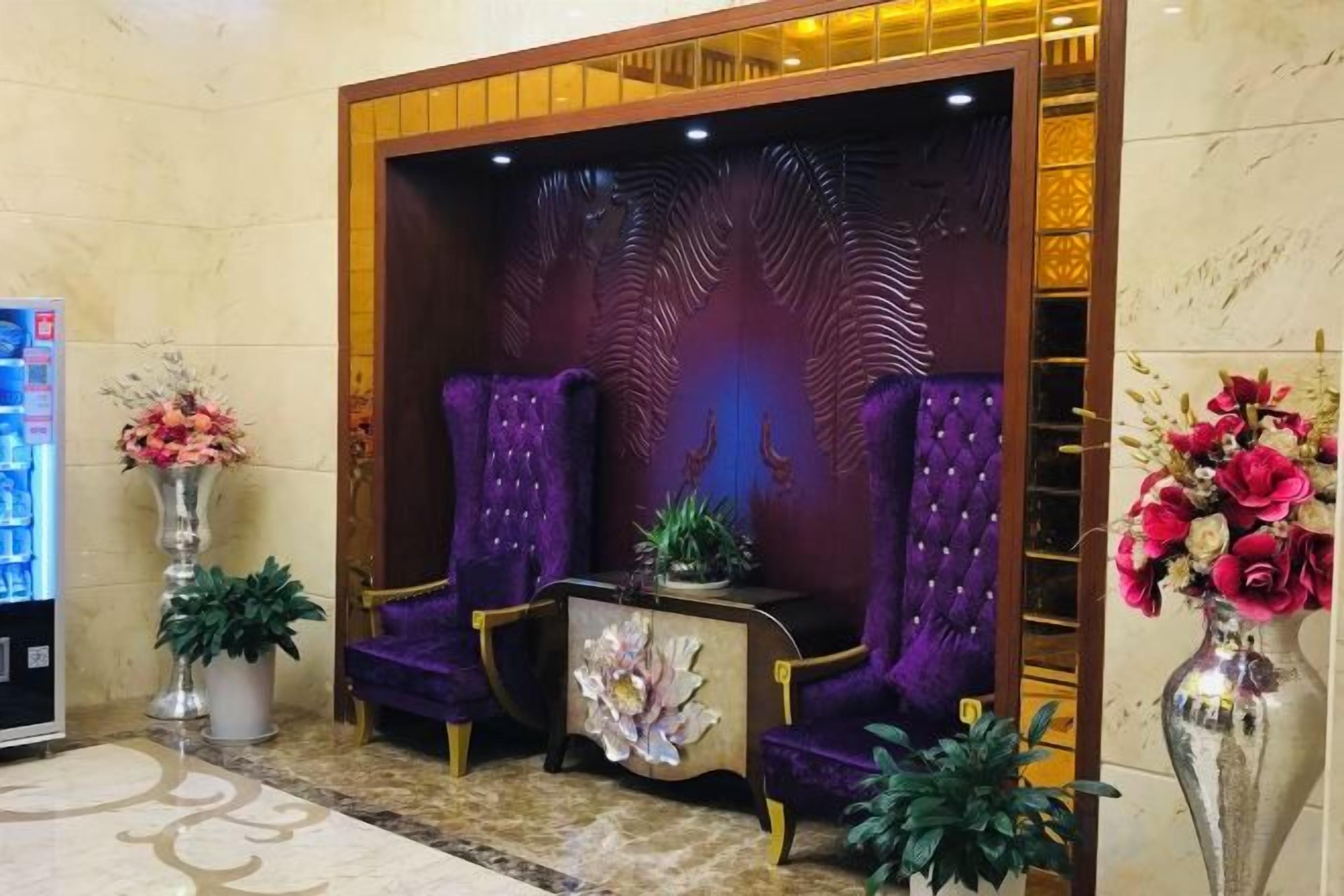 A reception area with a seating arrangement, a decorative wall, and potted plants.