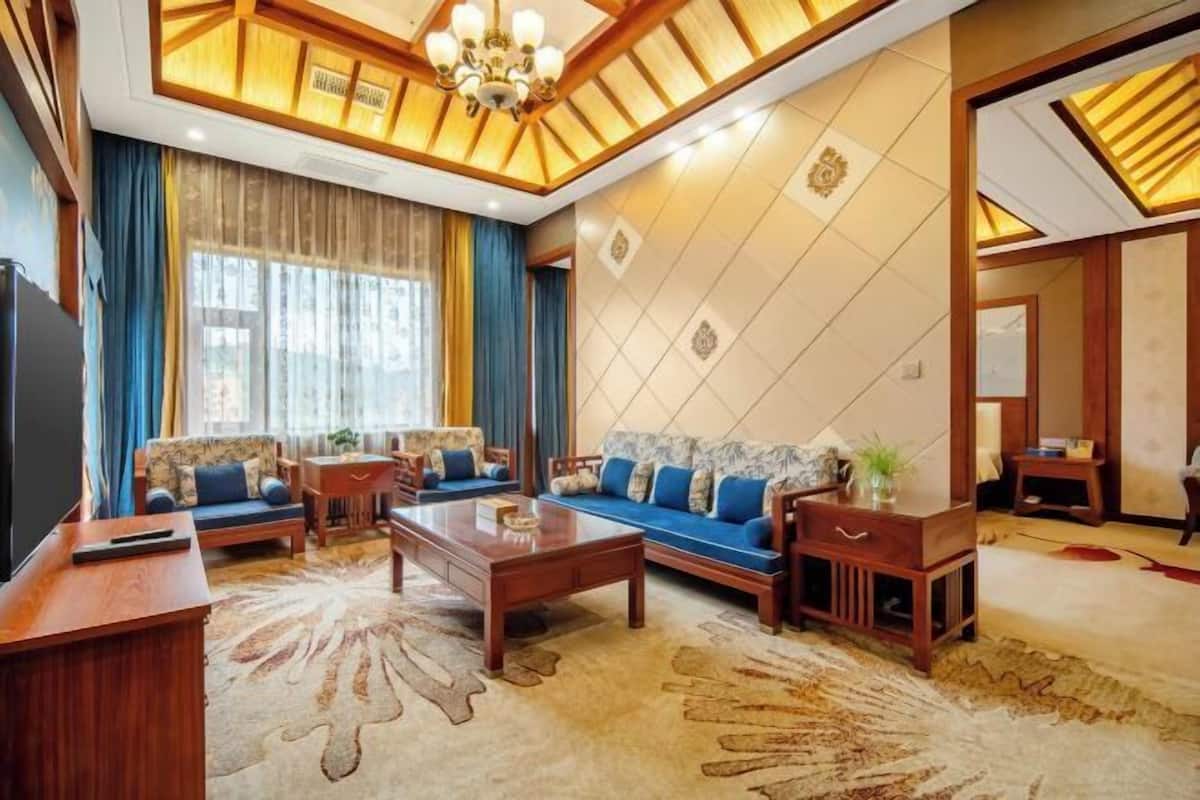 A spacious living room with a large sofa, a coffee table, and a TV.