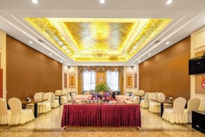 A conference room with a long table, chairs, and a decorative ceiling. - Menluo Wa Jing Luxury Grand Hotel(Hulu Town Wa Tribe Branch) (Cangyuan)